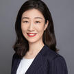 Woman  smiling with dark hair wearing a pinstripe blazer