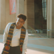 Action shot of black man smiling while wearing a African kente graduation sash