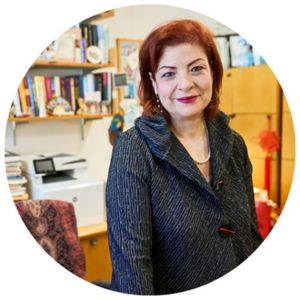 Georgia Perakis standing in front of a bookshelf and desk