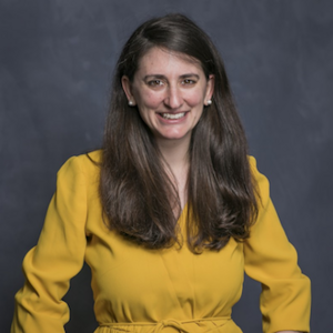 Headshot of a woman in a yellow dress.